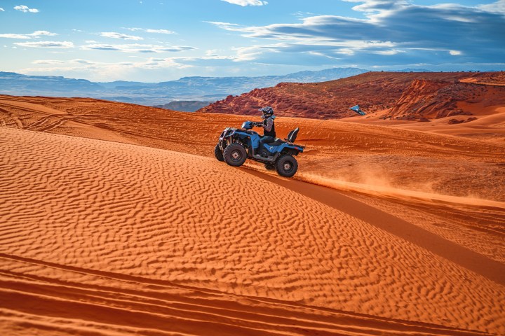 a motorcycle is parked on the side of a dirt field