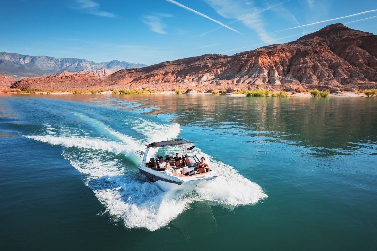 20′ Surf Boat Image 1 a small boat in a body of water with a mountain in the background