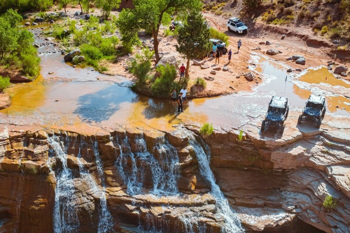 a group of people sitting on the side of a river